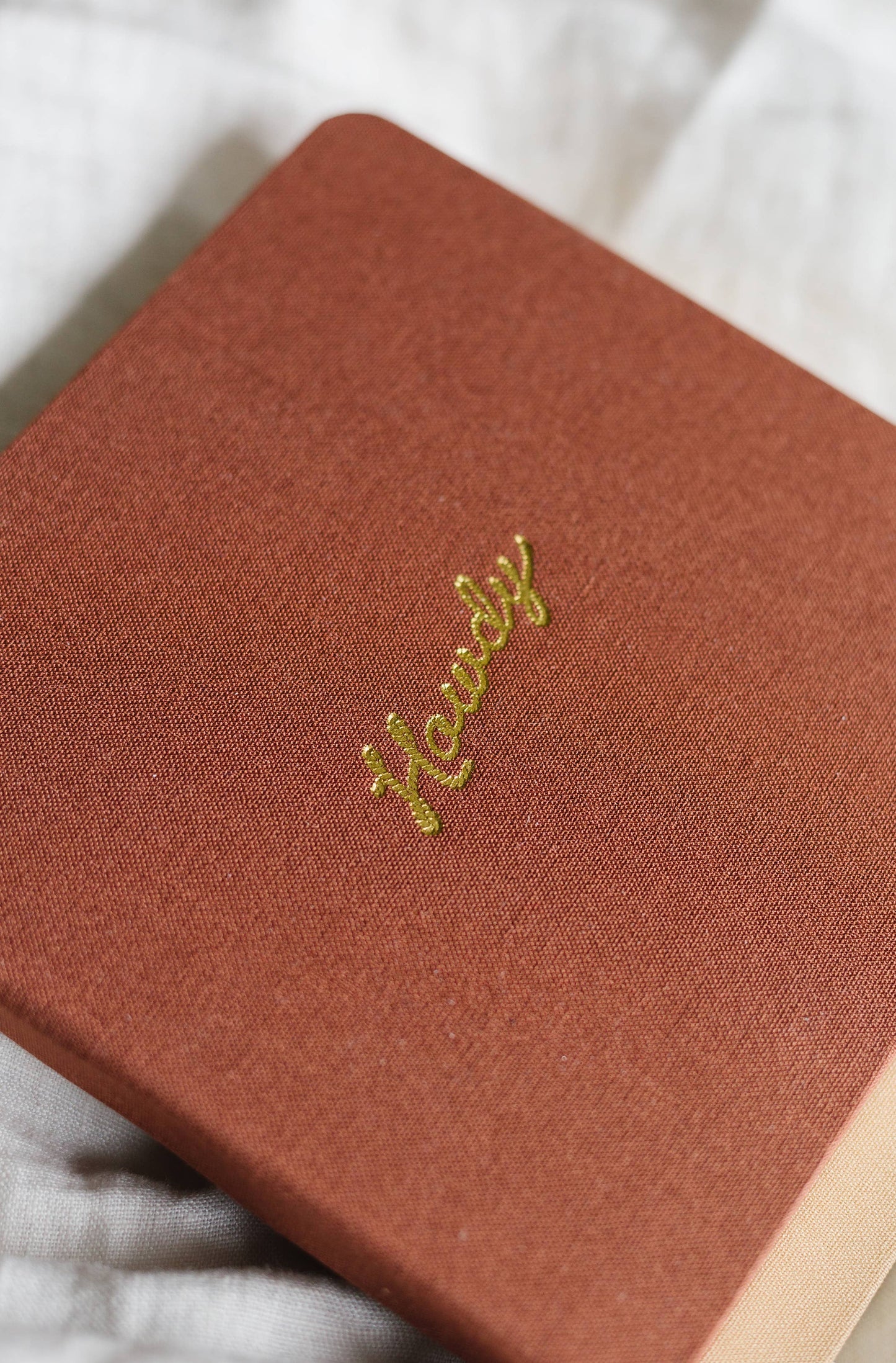 Portmanteau - Vierkant linnen notitieboek met reliëf Howdy goudfolie