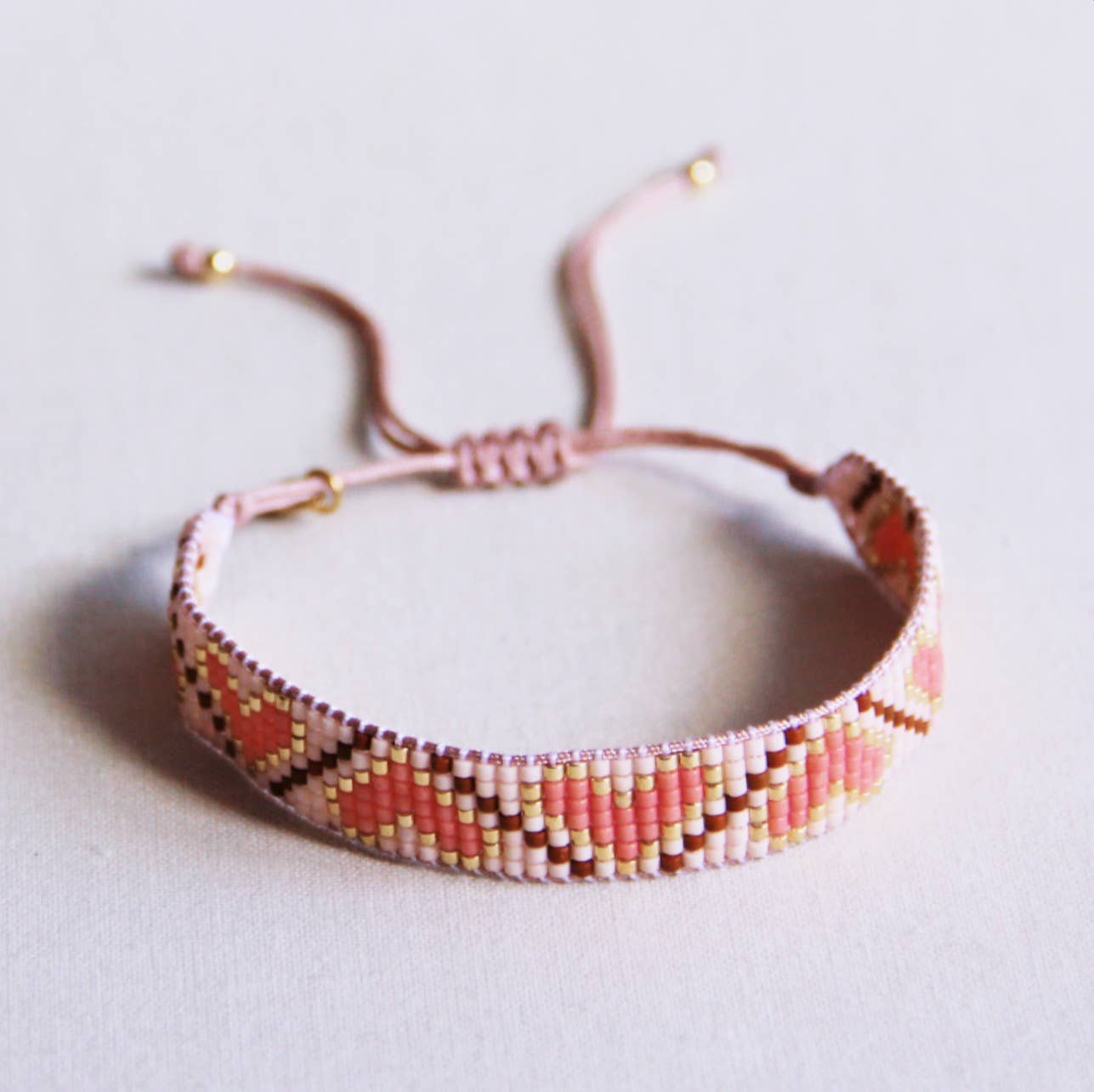 Bazou - Hartpatroon geweven armband koraal/cognac