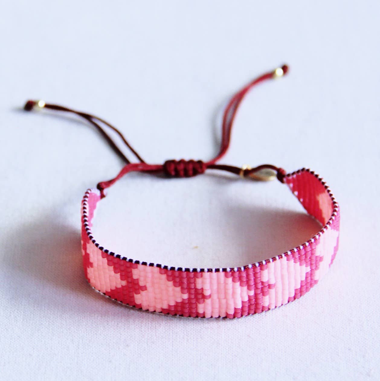 Bazou - Kraaltjes armband met hartjes felroze/ perzik