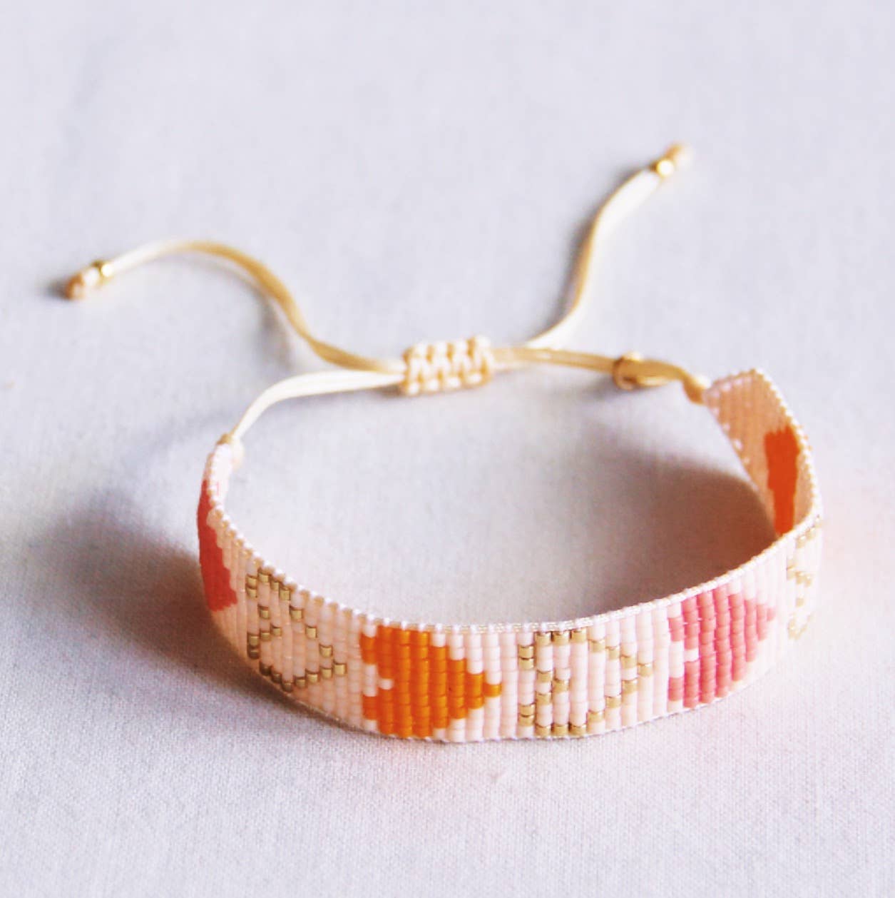 Bazou - Gevlochten armband met kraaltjes hartjes nude/oranje/zalmkleurig
